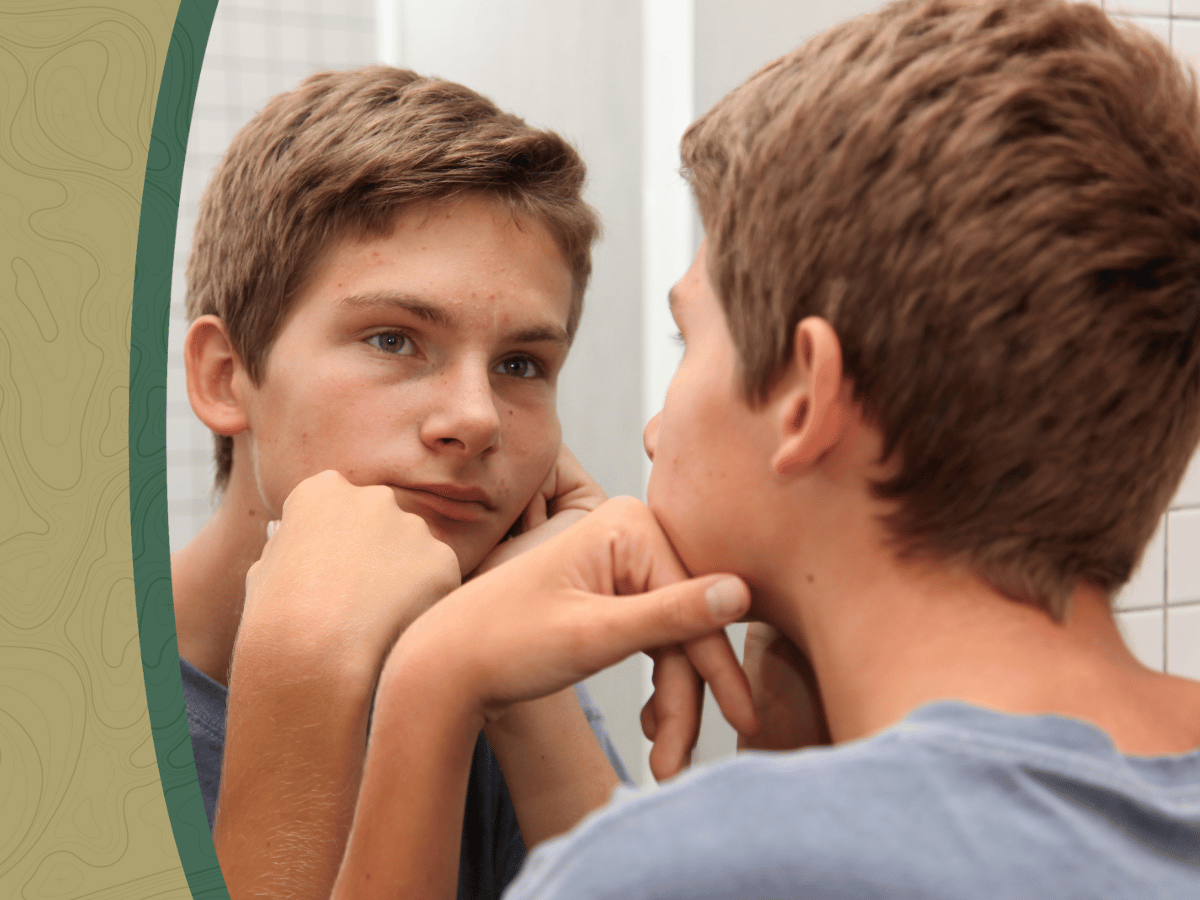 teen boy looking in mirror